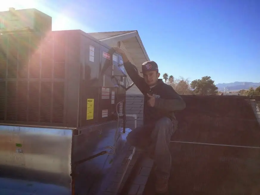 HVAC technician performing Boiler Repair on a rooftop unit in Addison